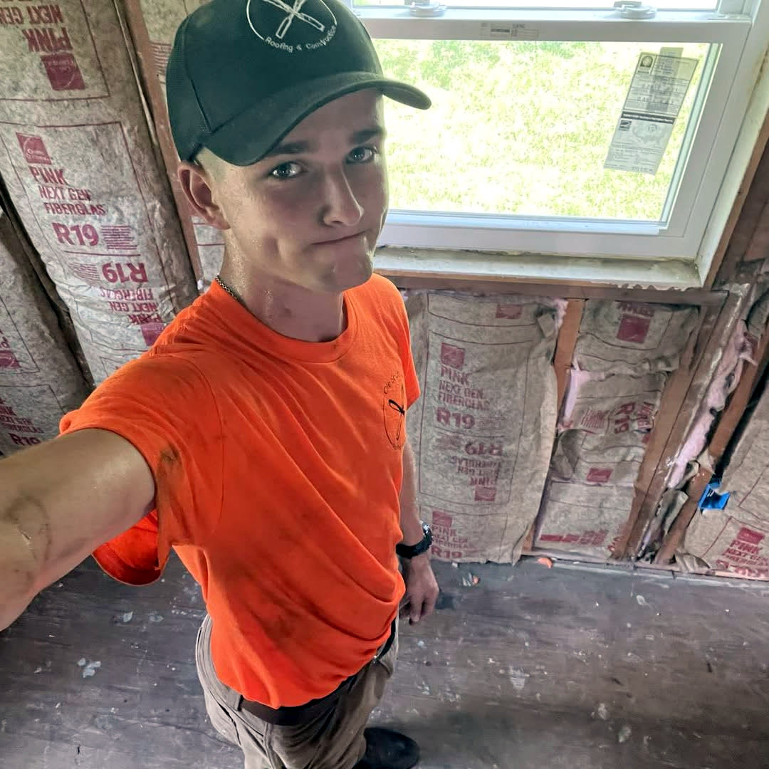Ole South crew member in company cap and shirt inside a gutted room mid-renovation