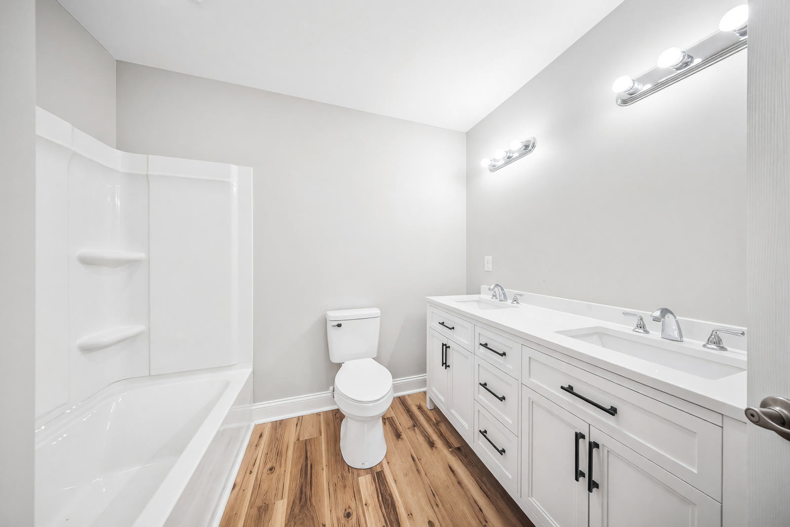 Finished bathroom with a double vanity, quartz top, and new lighting