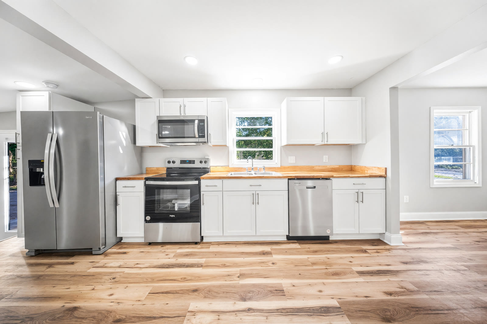 Kitchen we finished in a remodel — white cabinets, butcher-block counters, stainless appliances, new wood floors
