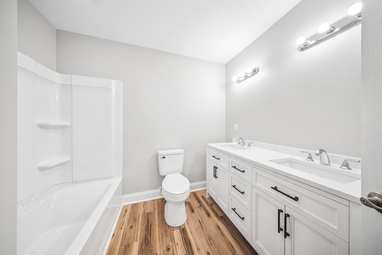 Bath we finished in the same remodel — double vanity, new tub and surround, the same new wood floors