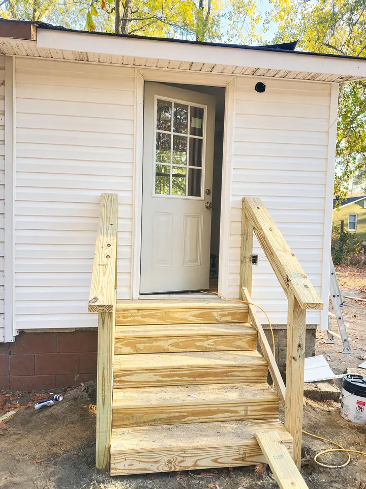 New white siding, stairs, and a nine-lite door
